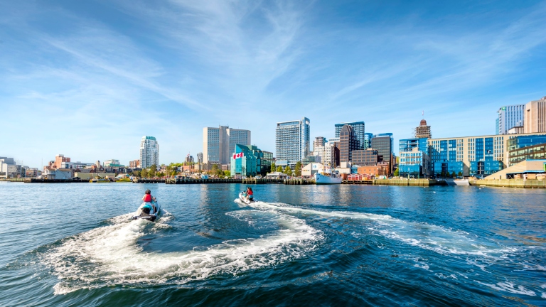Two people riding watercraft in harbour