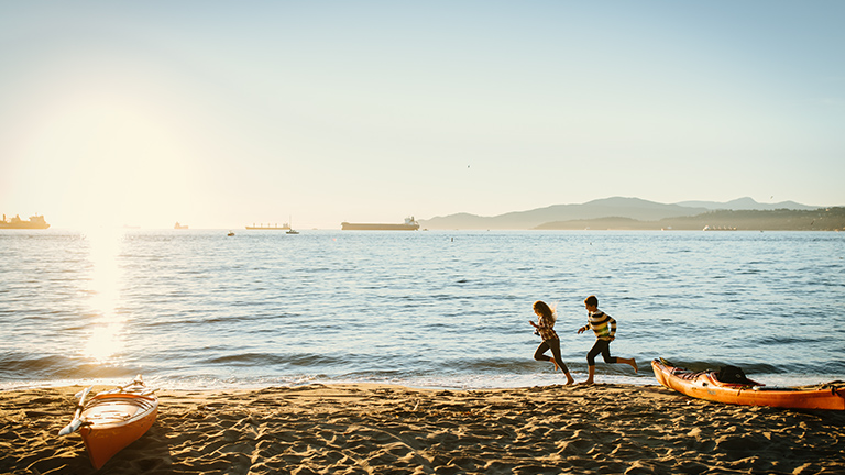 Kids running on beach as waves roll into shore